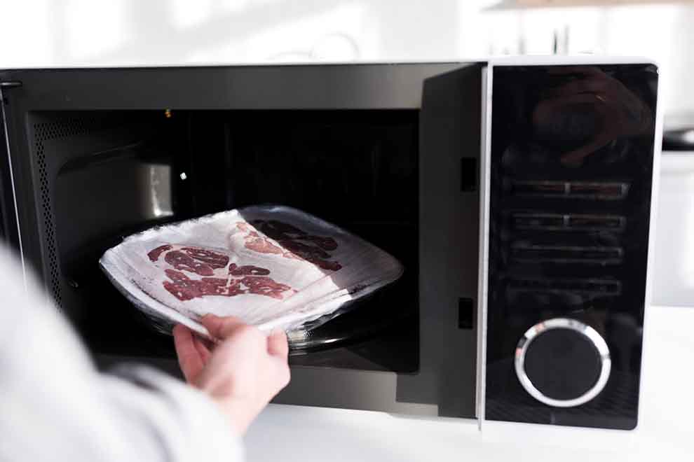descongelar carne  descongelar carne no microondas em uma cozinha clara