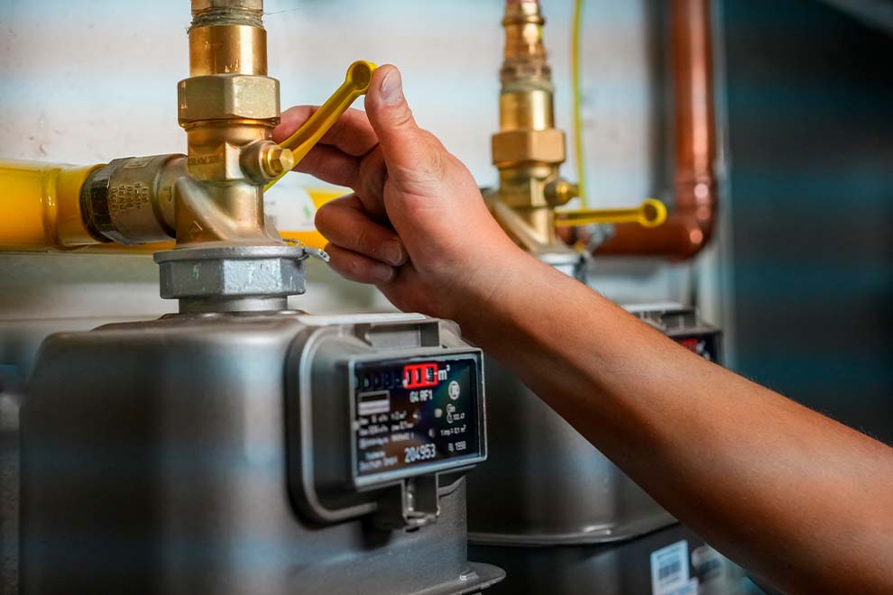 Pessoa ajustando registro de gás em medidor